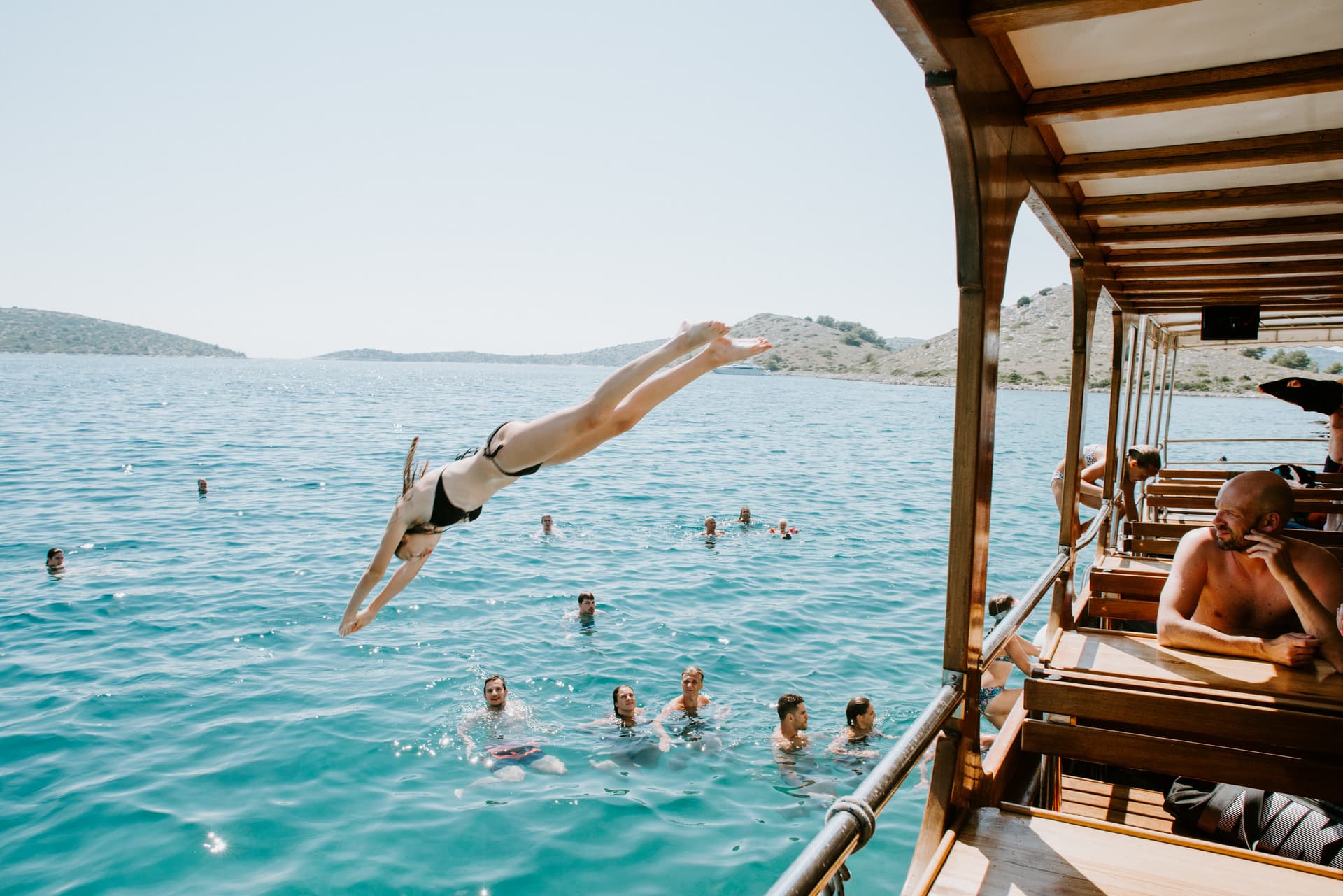 Guests jumping on the sea from the top deck